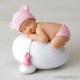 Figura niña bebé rosa durmiendo sobre huevo